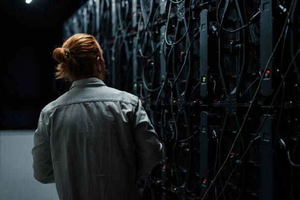 Video technician examining the back of a large led screen wall, checking cables and connection